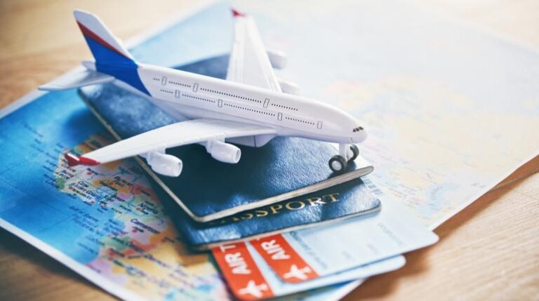 plane model with world map, passports and tickets as airplane traveling and tickets booking concept